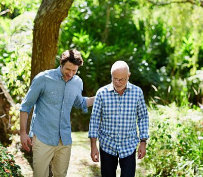 Happy senior man and son walking together in park
